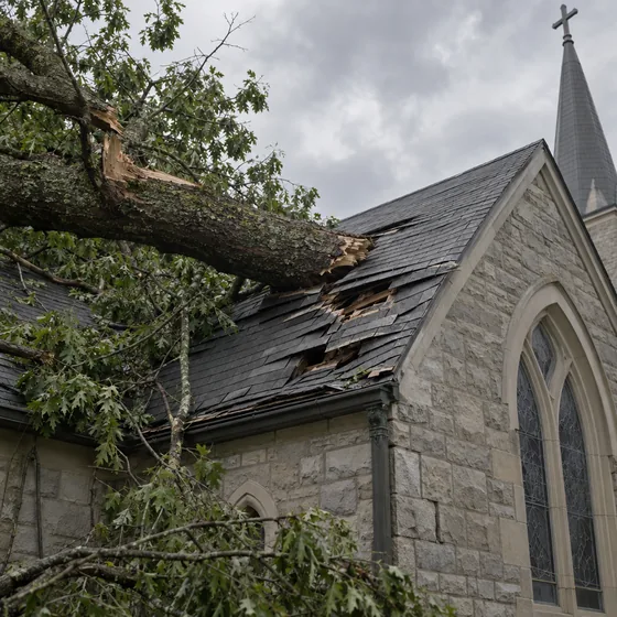 Fallen tree limb on church roof after severe storm damage